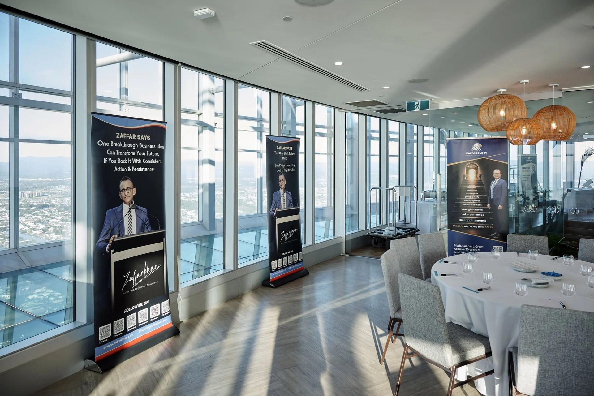 Zaffarology banners lined along the windows beside a set table, city and coastline visible outside