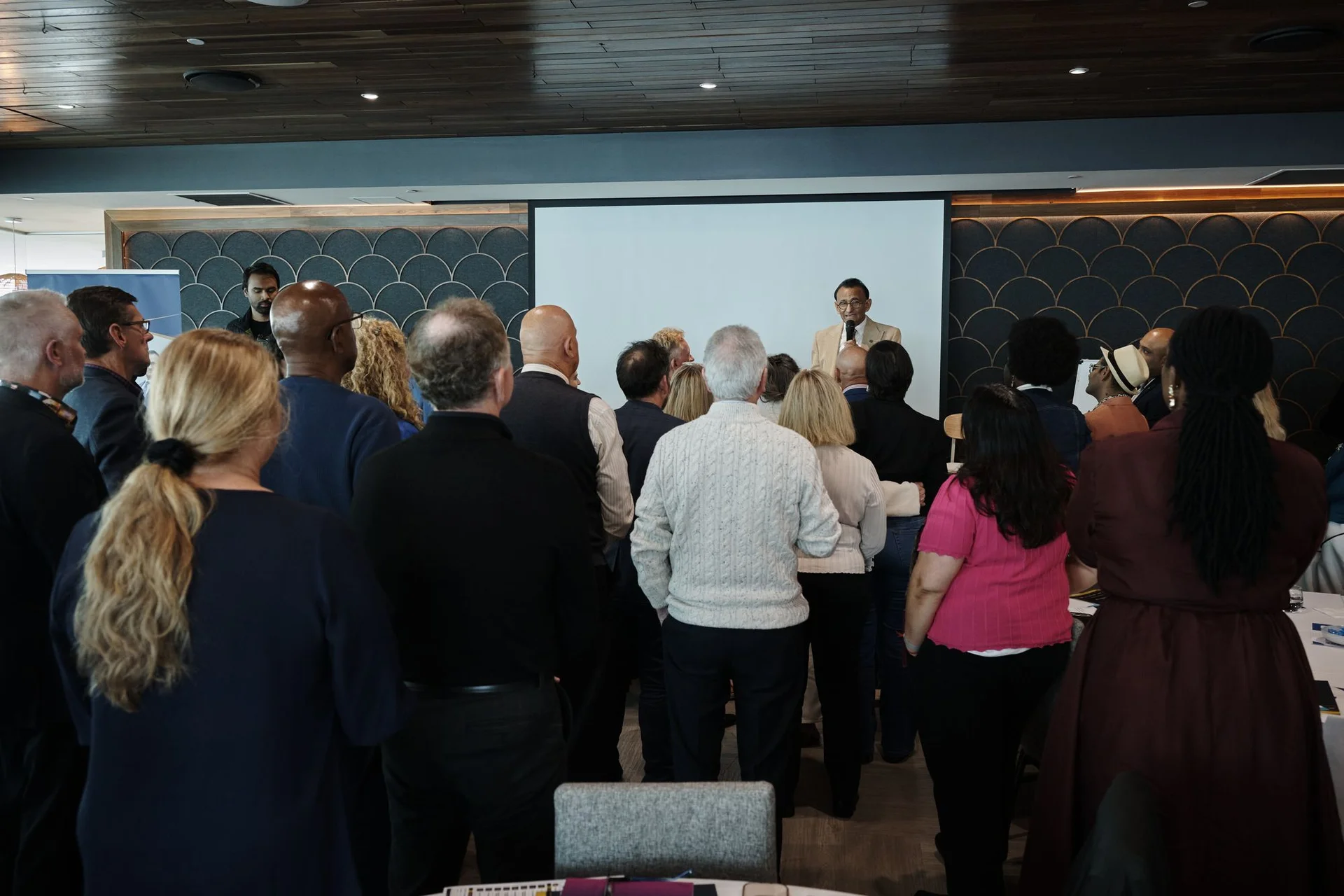 Attendees standing together facing the front during a group exercise